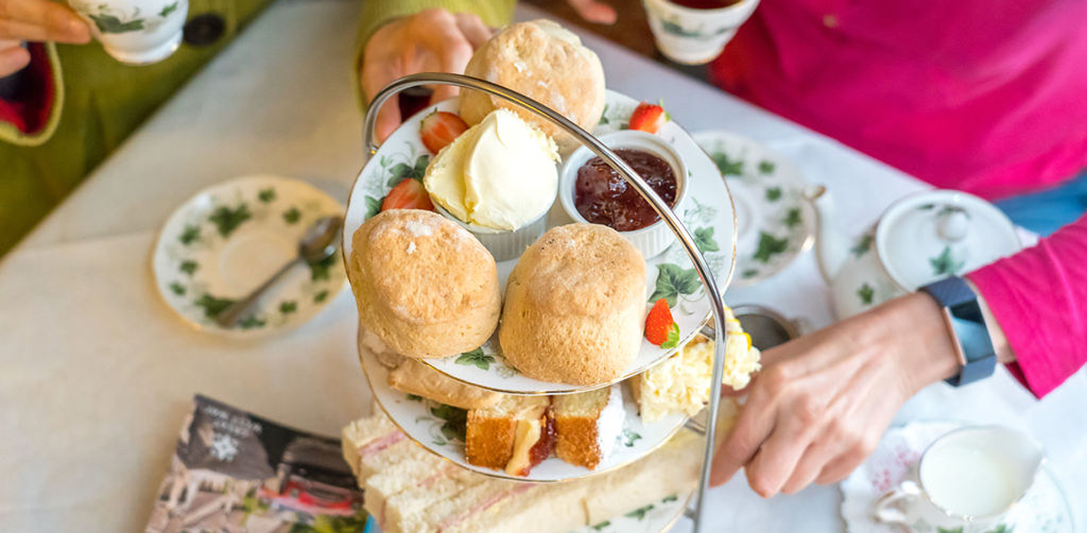 Table laden with tea, scones and sandwiches