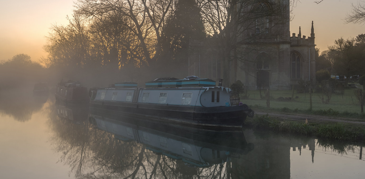 A narrowboat and a church in the mist