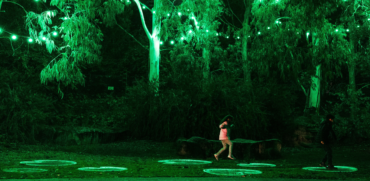 girl skips through green illuminated space