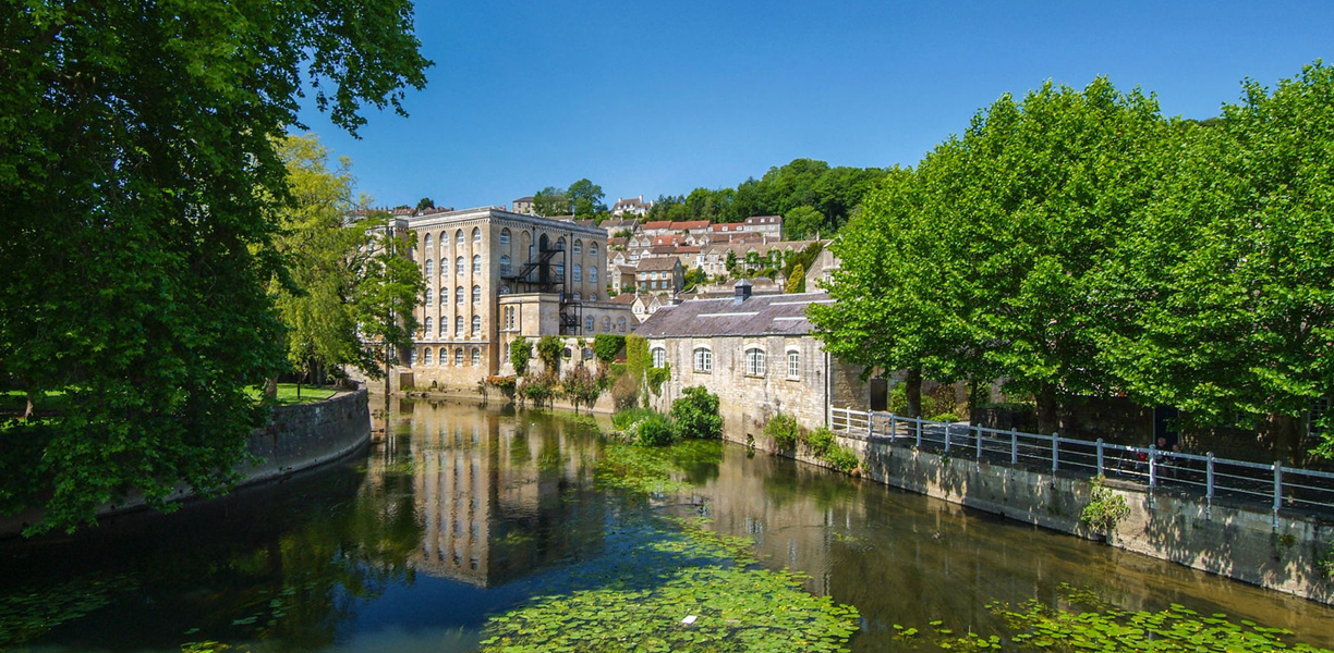 River Avon with stone buildings and trees around it