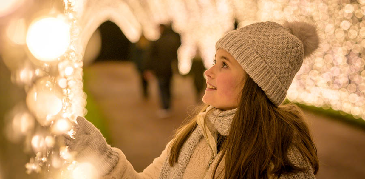 woman wrapped up warm looking at christmas lights